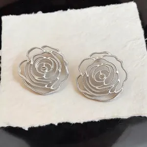 Elegant silver-colored hollow rose stud earrings featuring a refined beaded edge design