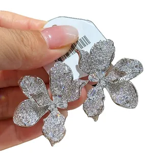 Elegant oversized zircon flower stud earrings with shimmering clear stones in silver finish