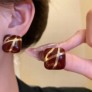 Elegant square burgundy enamel stud earrings with gold accents for a luxurious look