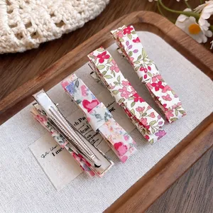 Set of floral fabric bow alligator hair clips on a wooden tray for sweet forest style
