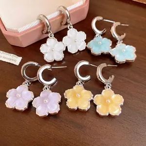 Eleganti orecchini a cerchio a C in argento con ciondoli a fiore in resina e perle.