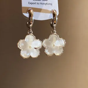 Eleganti orecchini a cerchio a C argentati con fiore in resina bianca e perla pendente.
