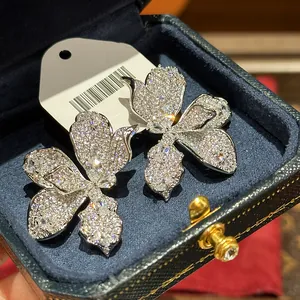 Detailed close-up of exquisite silver needle flower earrings set with sparkling zircons.