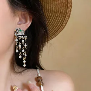 Luxurious vintage leopard head tassel earrings with black and white pearls on model