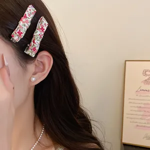 Close-up of elegant floral fabric hair clips worn by a model with a pearl earring