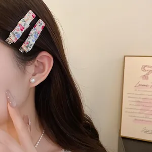 Detailed close-up of mori style floral fabric duckbill hair clips worn on side hair