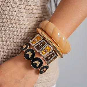 Detailansicht von Retro-Schmetterling-Armbändern und bernsteinfarbenen Armreifen