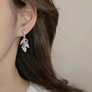 Vintage silver leaf drop earrings with sparkling zircon teardrop shown on a model.