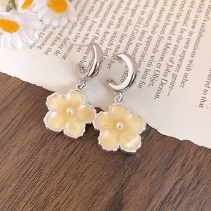 Orecchini a cerchio a forma di C con fiore in resina gialla e dettaglio di perla