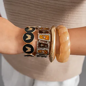 Retro Armband-Set mit goldenen Schmetterlingsmotiven und bernsteinfarbenen Harztexturen