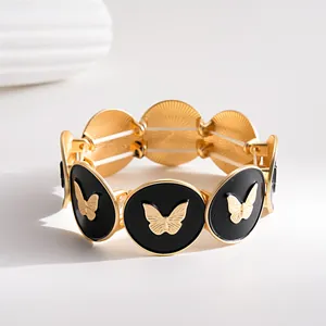 Detailansicht eines elastischen Armbands mit goldenen Schmetterlingsmotiven auf schwarzer Emaille