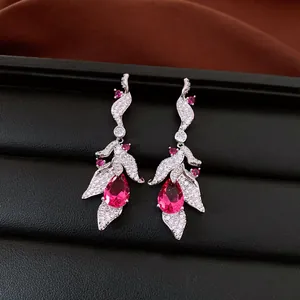 Macro detail of silver leaf earrings with vibrant teardrop-shaped pink stones