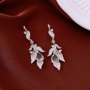 Close-up of vintage silver leaf earrings with pavé cubic zirconia and teardrop stones
