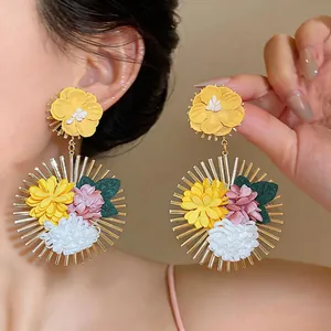 Close-up of exaggerated fabric flower drop earrings with a tropical vacation vibe