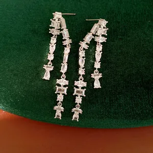 Detailed macro view of long tassel earrings featuring sparkling multi-shape cubic zirconia