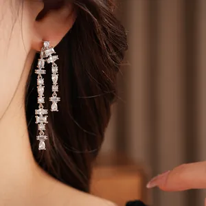 Detailed view of elegant sparkling cubic zirconia long tassel earrings on a model