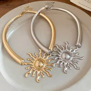 Detailed close-up of vintage metal sun pendant necklaces in gold and silver finish