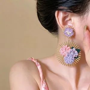 Detailed view of elegant Korean style fabric flower earrings worn by a female model for vacation