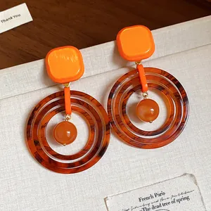 Detailed close-up of retro orange resin geometric earrings with tortoiseshell pattern