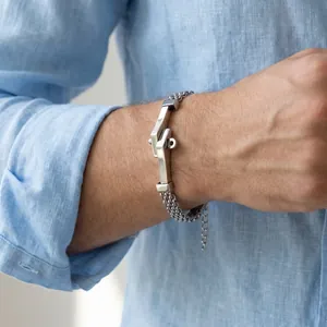 Detailopname van een herenarmband van roestvrij staal met een gebogen plaat om de pols