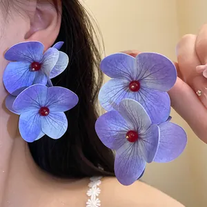 Elegant purple hydrangea flower earrings with red bead centers shown in close-up