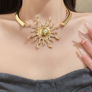 Close-up of vintage golden sunburst pendant necklace on model's neck
