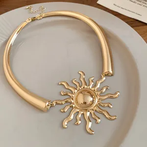 Detail of gold metal sun pendant necklace with sleek vintage minimalist design