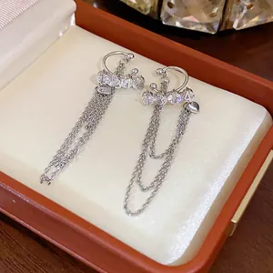 Detail view of elegant silver-colored zircon tassel ear clips presented in a jewelry gift box