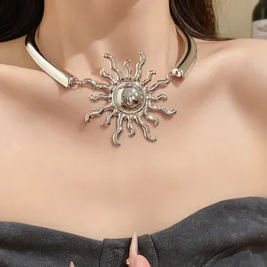 Close-up detail of a large silver metal sun pendant choker necklace worn by a model