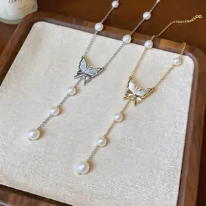 Exquisite detail of gold and silver plated butterfly necklaces with pearl beads on tray