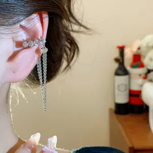 Close-up view of silver zircon number 2024 ear cuff with a hanging heart and chain tassel