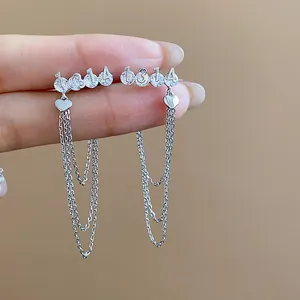Macro view of silver number 1314 earrings with zircon stones and multi-layered chain tassels.