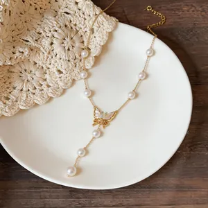 Detailed view of 18K gold plated butterfly necklace with white pearls and zircons