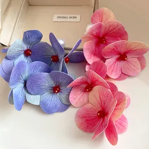 Detailed close-up of handmade blue and pink hydrangea flower earrings with pearls