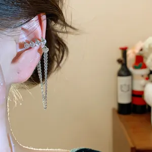 Close-up of zircon number 1314 ear cuff with heart and chain tassels.