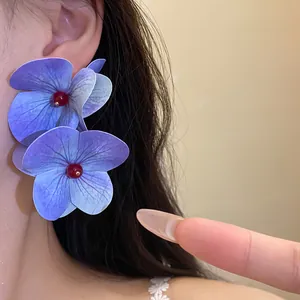 Close-up of purple hydrangea flower earrings on ear for a sweet seaside holiday look