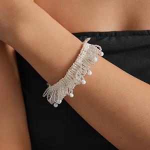 Détail d'un ras-de-cou tissé en perles de verre blanches avec dentelle