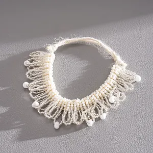 Gros plan d'un ras-du-cou en perles de verre blanches avec détails en dentelle tissée