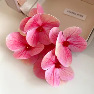 Detailed shot of elegant pink fabric hydrangea flower earrings with red bead center