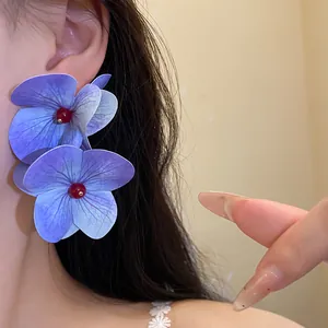 Detailed close-up of purple hydrangea flower earrings showing delicate petal texture and vibrant color.