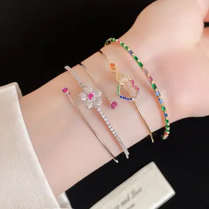 Vue détaillée de bracelets superposés plaqués or 14K avec cœur et fleurs en zircone