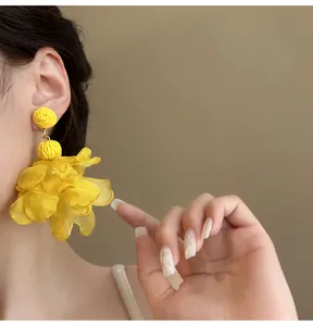 Close-up of yellow chiffon flower petal earrings with bohemian beach vacation style