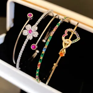 Gros plan de bracelets en zircon plaqués or 14K avec motifs fleurs et cœurs.
