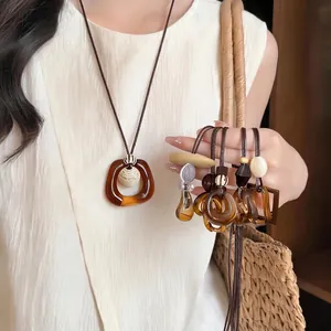 Retro Maillard style amber geometric resin pendant long necklace for women on model