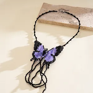 Close-up detail of handmade purple and black beaded butterfly tassel statement necklace