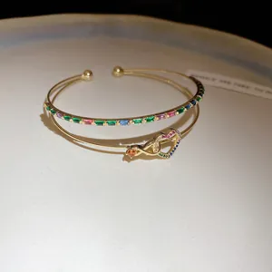 Gros plan sur un bracelet jonc double couche en plaqué or 14K avec cœurs et zircons