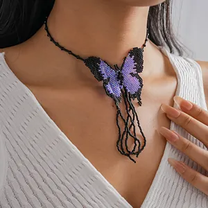 Detail shot of handcrafted beaded butterfly necklace in purple and black contrast