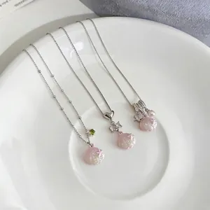 Stainless steel necklace with pink shell pendant and heart ribbon bow detail