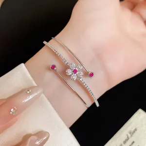 Élégant bracelet jonc à deux rangs avec motif fleur scintillant et pierres roses au poignet