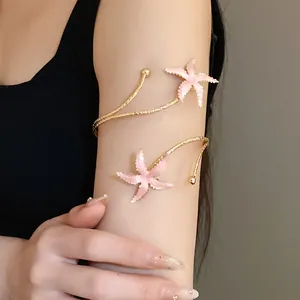 Détail d'un bracelet de bras étoile de mer rose avec un design en spirale en métal doré sur modèle